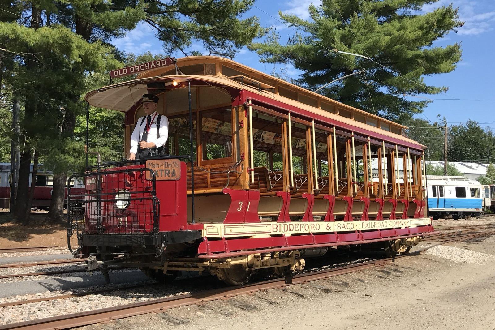 A restored Biddeford & Saco Railroad open streetcar, car 31, on the tracks at the Seashore Trolley Museum, with a conductor at the front platform and Old Orchard on the destination sign.